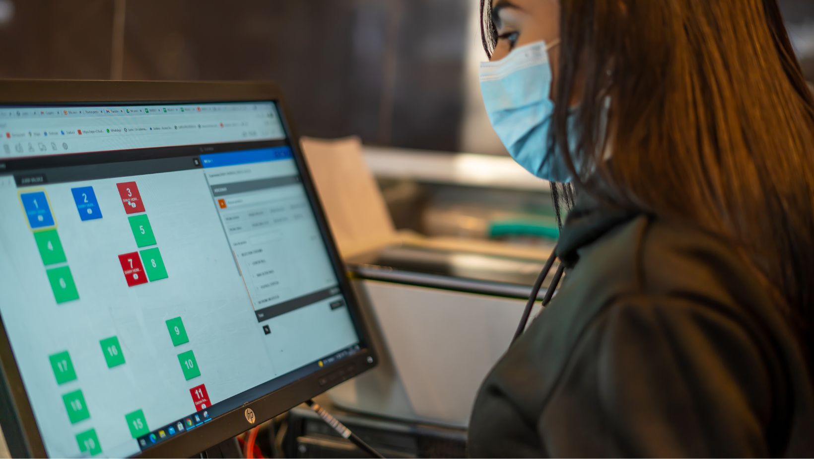 empleada de restaurante mirando una computadora que contiene un software de administración